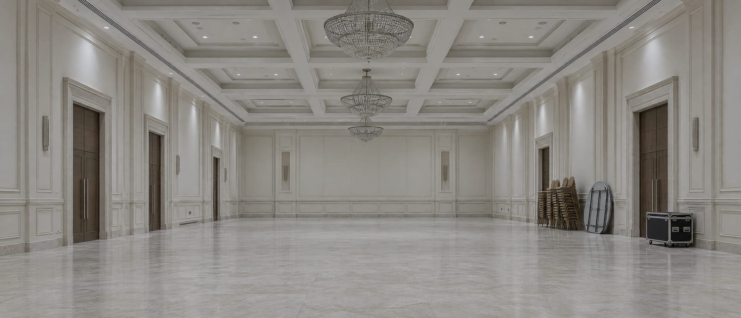 Concept image: an empty hotel ballroom under work lights before setup