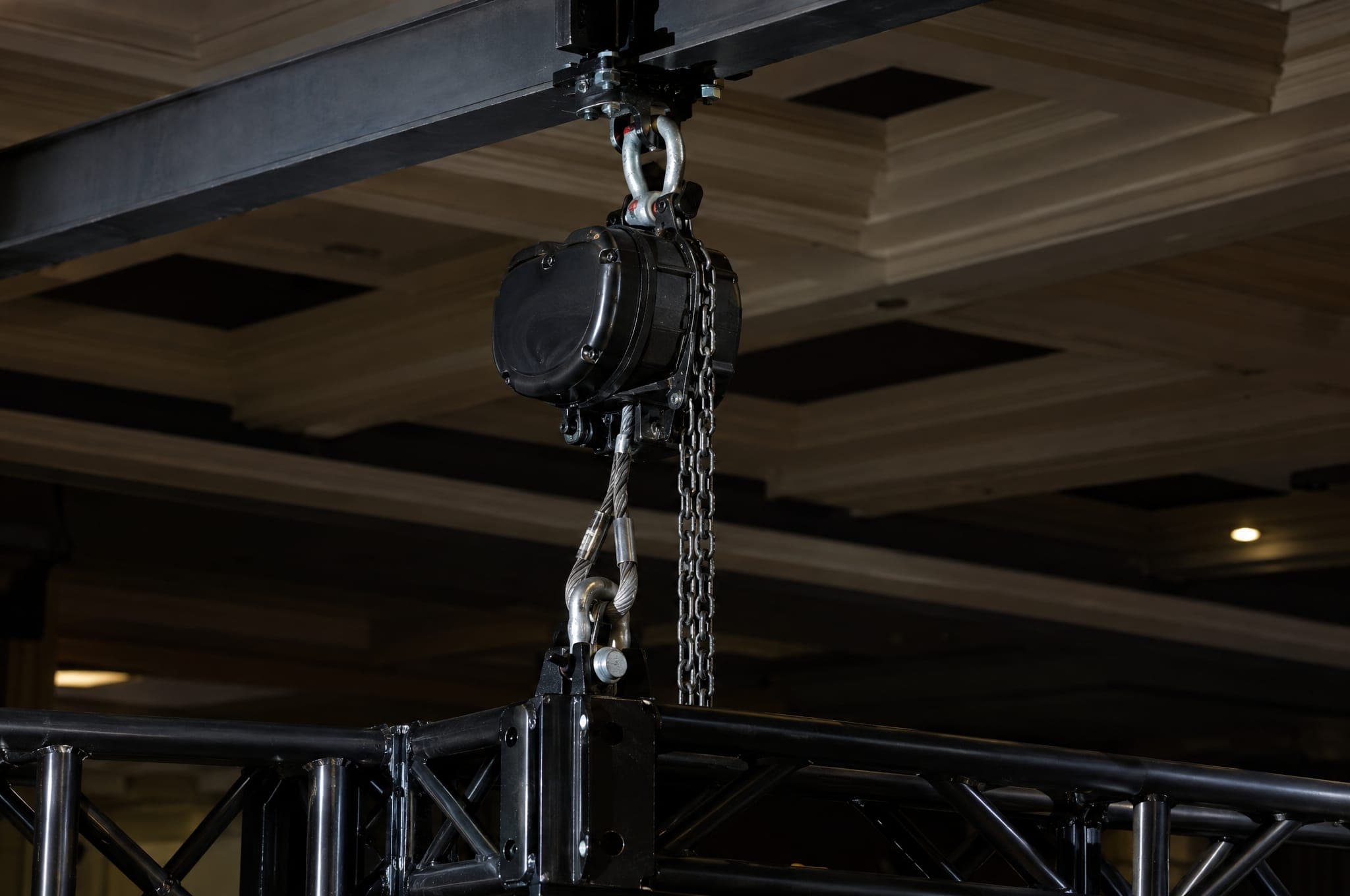 A chain hoist and truss secured at a ceiling rigging point