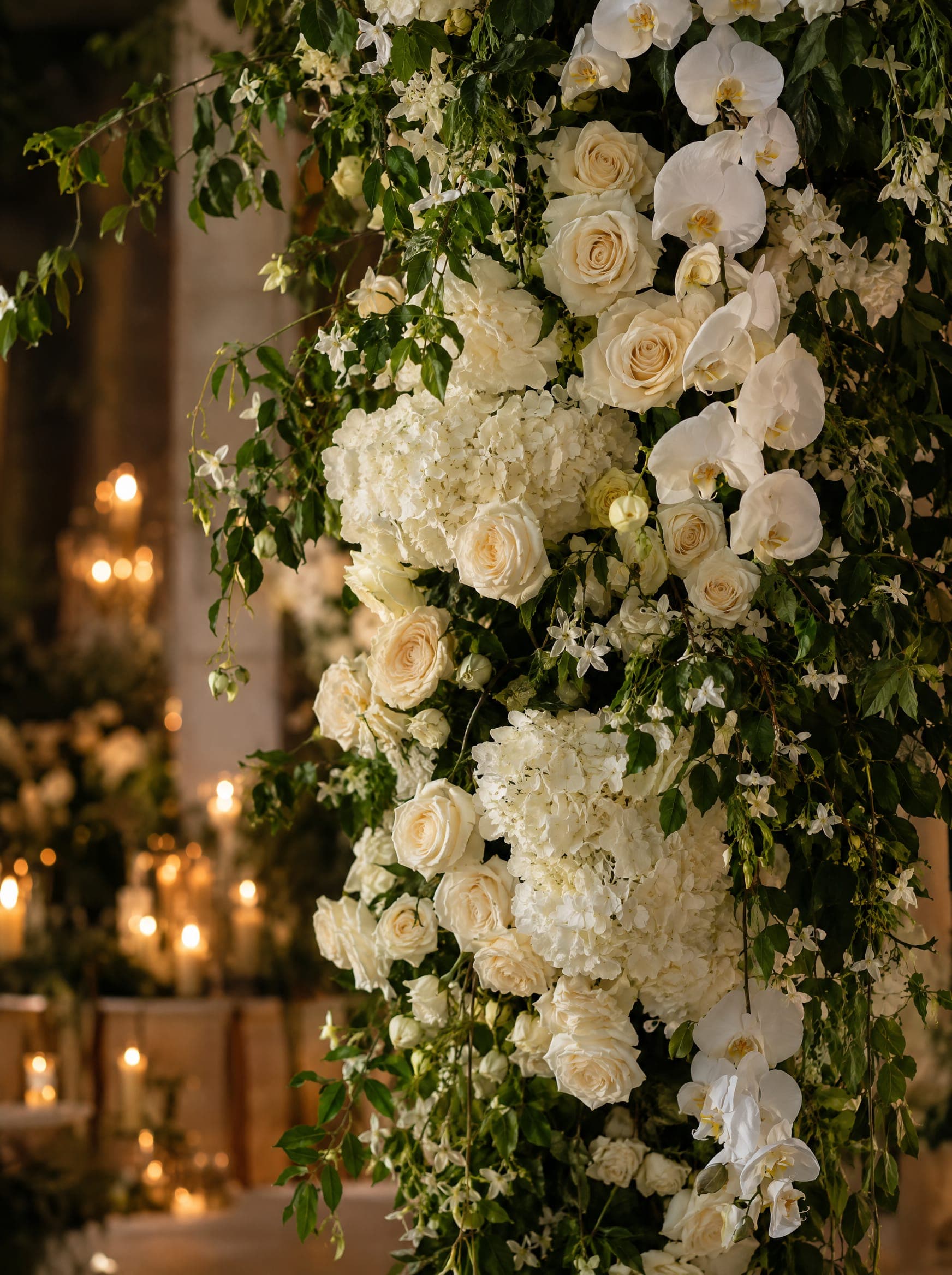 A dense installation of white roses, hydrangeas and orchids